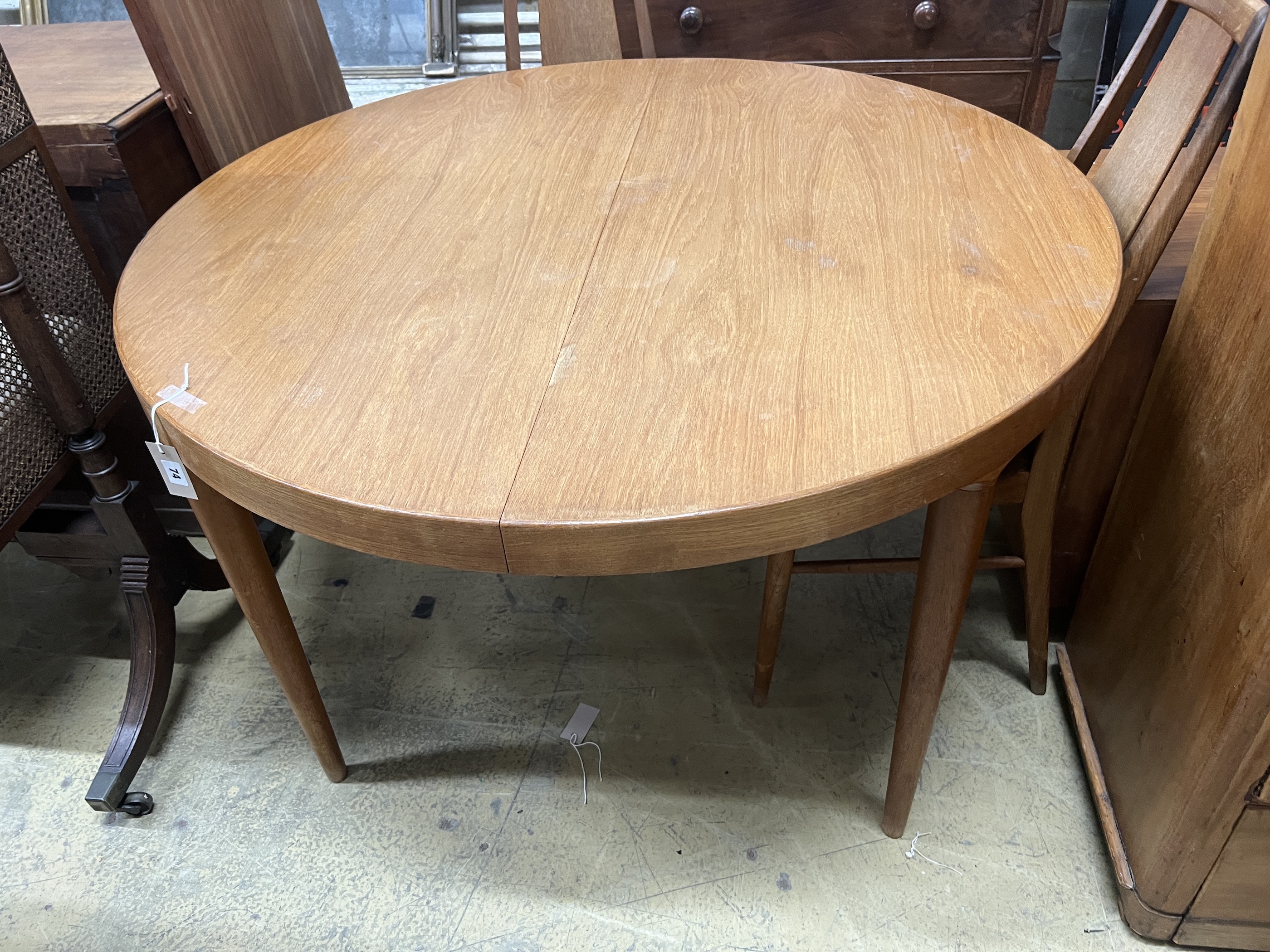 A mid century circular teak extending dining table, length 130cm extended, two spare leaves, depth 120cm, height 72cm